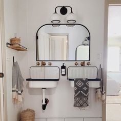 a bathroom with two sinks and mirrors on the wall next to a rug in front of it