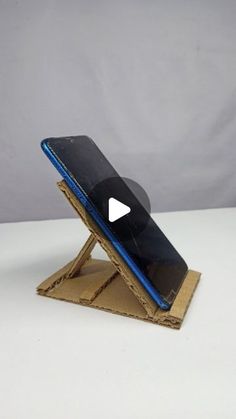 a cell phone sitting on top of a wooden stand with a video player in it