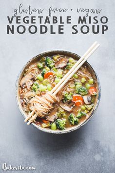 a bowl of vegetable miso noodle soup with chopsticks on the side