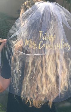 the back of a woman's head wearing a veil with words written on it