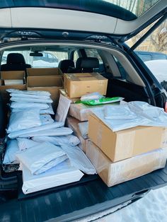 the back of a car packed with boxes and packages in the snow, ready to be loaded