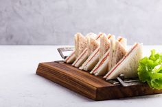 several sandwiches on a cutting board with lettuce