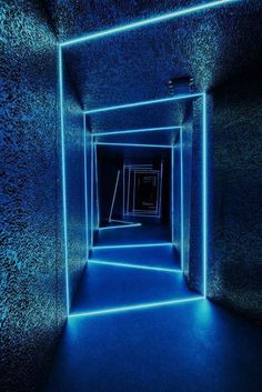 an empty room with blue light coming from the ceiling and walls, all lit up by neon lights