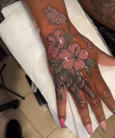 a woman's hand with flowers painted on it