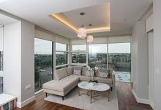 a living room filled with furniture and large windows