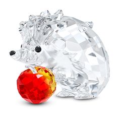 a crystal hedge with an apple in its mouth, on a white background and the image appears to have been cut out