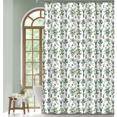 a white shower curtain with green leaves and pineapples on it in front of a window