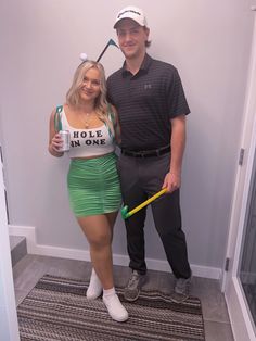 a man standing next to a woman holding a golf club