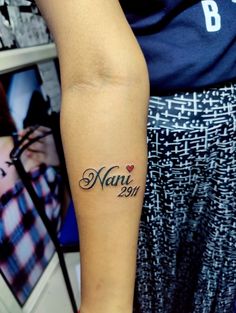 a woman with a tattoo on her arm that reads nani 2012 and has a heart