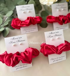 four red scrunffles with pearls on them are sitting next to each other