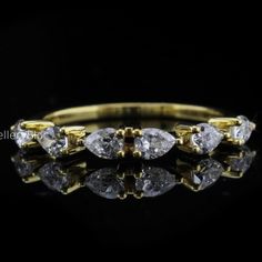 a gold ring with three pear shaped diamonds