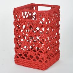 a red crocheted basket sitting on top of a white table