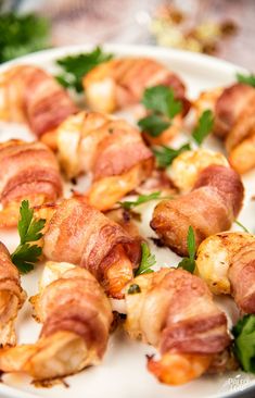 bacon wrapped chicken bites on a plate with parsley sprinkled around the edges