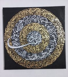 an intricately designed painting with gold and black accents on a white wall, depicting the calligraphy in arabic script