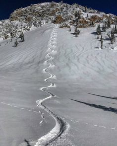 a man riding skis down the side of a snow covered slope