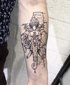 an elephant tattoo on the arm with flowers and other things in it's body