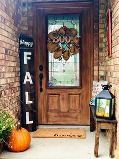 a front door with a happy booy wreath on it and an autumn decoration in the window