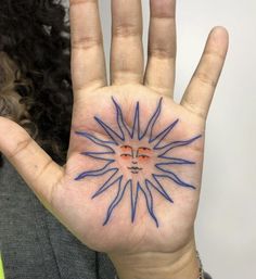 a woman holding up her hand with blue ink on it