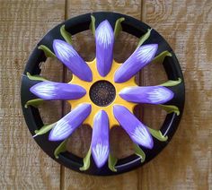 a purple and yellow flower sitting on top of a wooden table