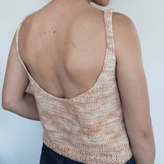 a woman with her back turned to the camera, wearing a knitted tank top