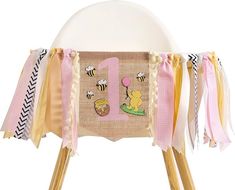 a wooden chair with a number one banner on it's back and some ribbons around the legs