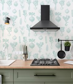 a stove top oven sitting next to a wall mounted exhaust hood over a kitchen counter