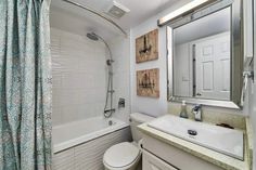 a bathroom with a sink, toilet and bathtub next to a shower curtain in it