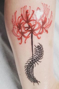 a red and black flower tattoo on the leg