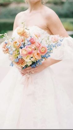 a woman in a wedding dress holding a bouquet of flowers