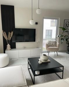 a living room filled with furniture and a flat screen tv mounted to the side of a wall