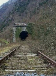 an old train track going into a tunnel