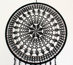 a black and white dream catcher hanging on a wall