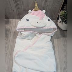 a white unicorn sleeping bag with a pink and gold horn on it's head