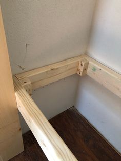 the corner of a room that is being built with wooden planks and plywood