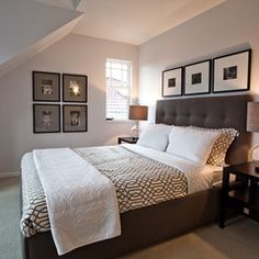 a bedroom with a bed, nightstands and pictures hanging on the wall above it