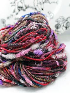 a pile of multicolored yarn sitting on top of a white table