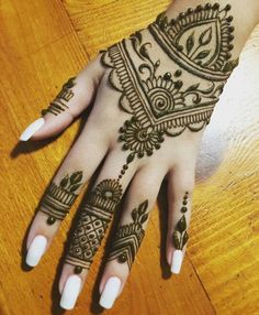 a woman's hand with henna tattoos on it