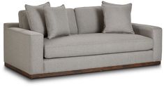 a gray couch with four pillows on it's back and two sides, sitting in front of a white background