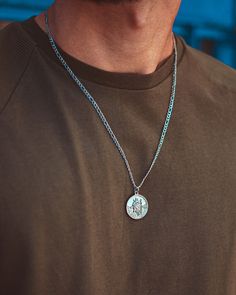 Silver St Christopher Pendant necklace. This striking piece is going to take centre stage on your outfit. Be bold and rock this on its own or with a combination of silver accessories- just take a look on our necklace page. Model is wearing a 22" Figaro chain on this necklace - this is sent as standard unless another chain style or length is selected in the personalisation section. Made from Premium quality 316L stainless steel with a Polished Silver stainless steel finish. Guaranteed to never fa Silver Figaro Chain Jewelry With Round Pendant, Silver Jewelry With Figaro Chain And Round Pendant, Silver Figaro Chain Medallion Jewelry, Silver Medallion Figaro Chain Jewelry, Silver Medallion With Figaro Chain, Silver Figaro Chain Pendant Necklace, Silver Pendant Necklace With Figaro Chain, St Christopher Necklace, St Christopher Pendant