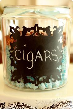 a glass jar filled with lots of blue and white candy sitting on top of a table