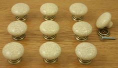 several white knobs and handles on a wooden surface