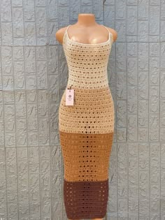 a crocheted dress is displayed on a mannequin's head stand