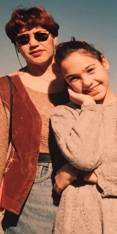 two women standing next to each other with their arms around one another