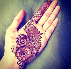 a woman's hand with henna tattoos on it