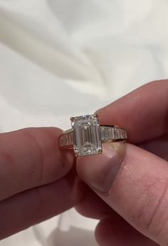 a person holding an engagement ring in their left hand with a diamond on the other side