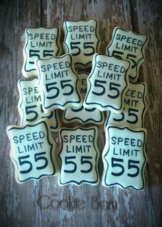 six decorated cookies with speed limit and 55 on them are sitting on a wooden table