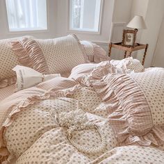 an unmade bed with pink and white comforters