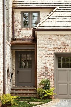 a brick house with two garage doors and steps leading up to the front door is shown