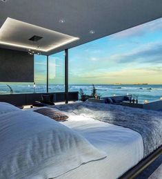 a large bed sitting next to a window in a bedroom under a sky light at night