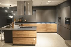 a modern kitchen with stainless steel appliances and wood cabinets, along with white tile flooring